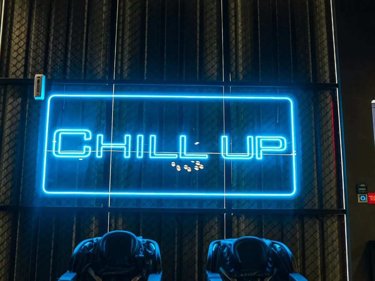 Massage chairs under the CHILL UP neon sign at Level Up Fitness Xpress Tebrau